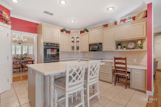 kitchen with black appliances, light tile patterned floors, an island with sink, and a breakfast bar area