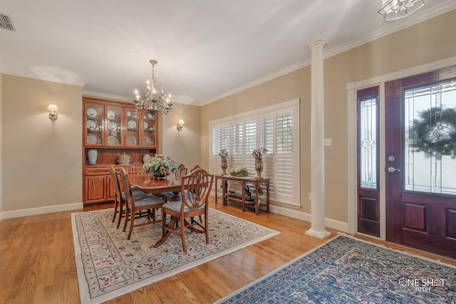 dining space with crown molding, light hardwood / wood-style floors, and decorative columns