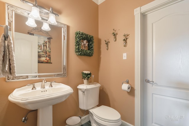 bathroom with toilet and crown molding