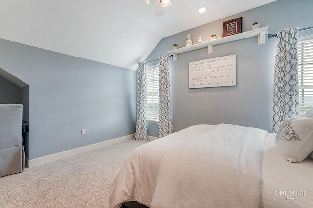 carpeted bedroom featuring multiple windows, lofted ceiling, and ceiling fan