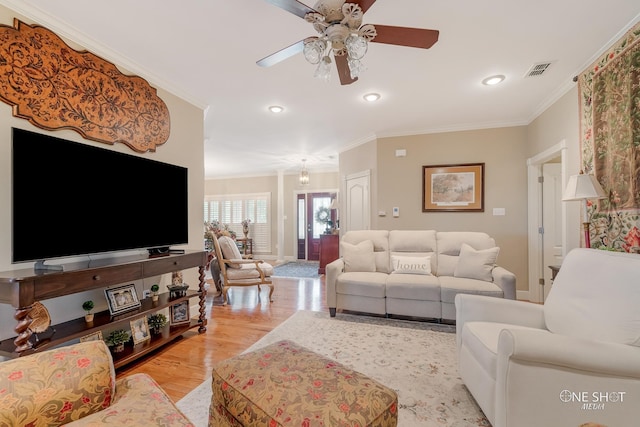 living room with light hardwood / wood-style flooring, ceiling fan, and ornamental molding