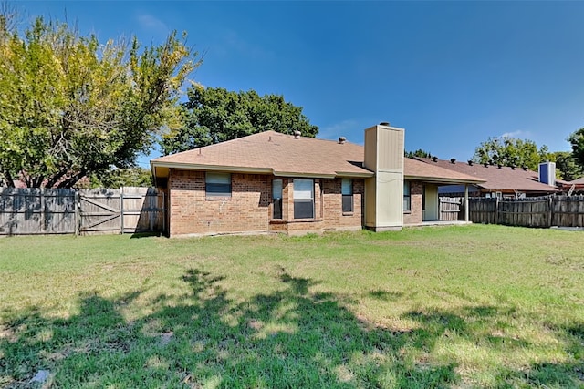 rear view of property with a lawn