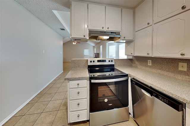 kitchen with appliances with stainless steel finishes, a textured ceiling, light tile patterned floors, and white cabinets