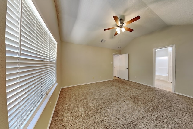 carpeted spare room with lofted ceiling, ceiling fan, and a textured ceiling