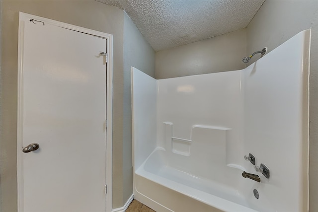 bathroom featuring bathing tub / shower combination and a textured ceiling