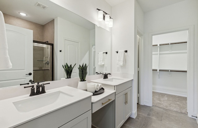 bathroom featuring vanity, tile patterned flooring, and walk in shower