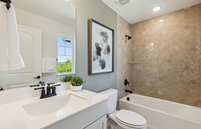 full bathroom with vanity, toilet, and tiled shower / bath combo