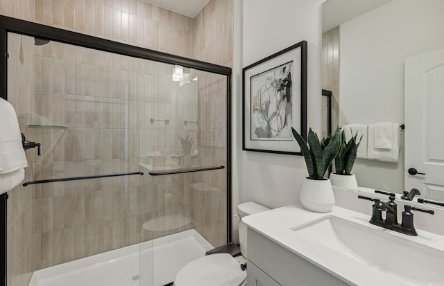 bathroom with an enclosed shower, vanity, and toilet