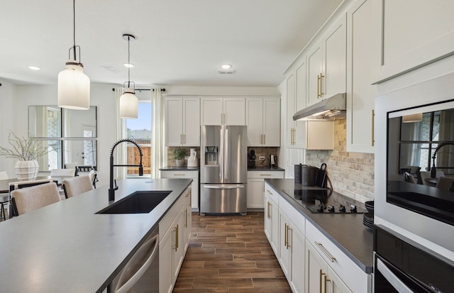 kitchen with decorative light fixtures, sink, dark hardwood / wood-style floors, white cabinets, and appliances with stainless steel finishes