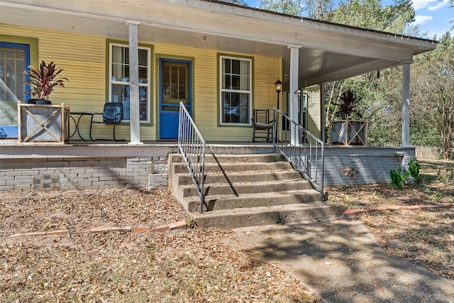 view of exterior entry featuring covered porch