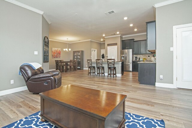 kitchen featuring a center island with sink, light hardwood / wood-style floors, a breakfast bar area, and appliances with stainless steel finishes