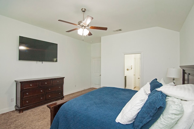 bedroom featuring lofted ceiling, light carpet, ensuite bathroom, and ceiling fan