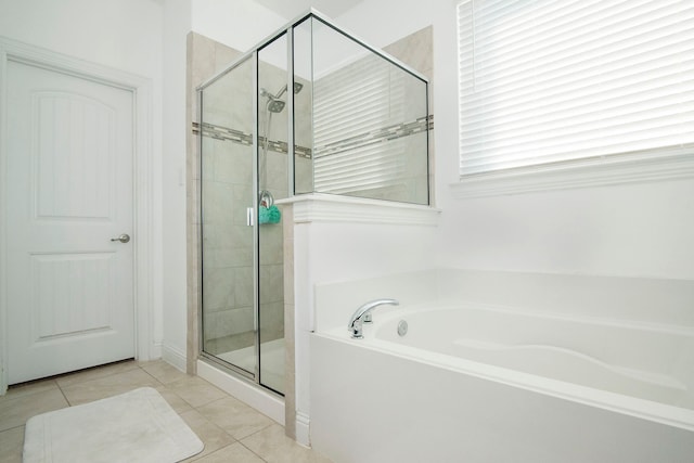 full bath featuring a shower stall, a bath, and tile patterned floors