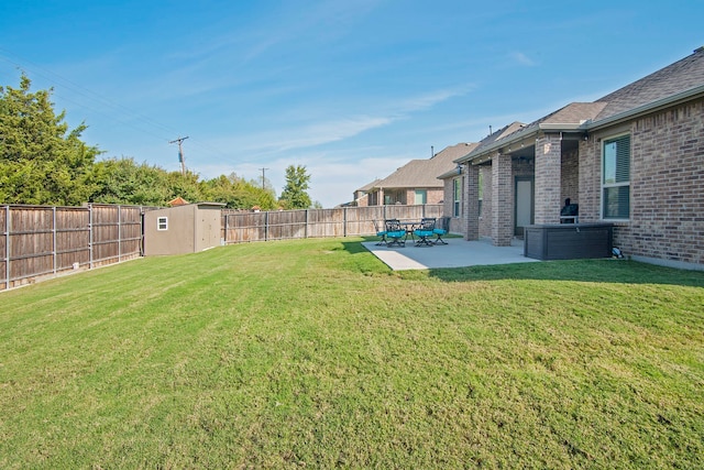 view of yard with an outbuilding, a storage unit, a patio area, and a fenced backyard