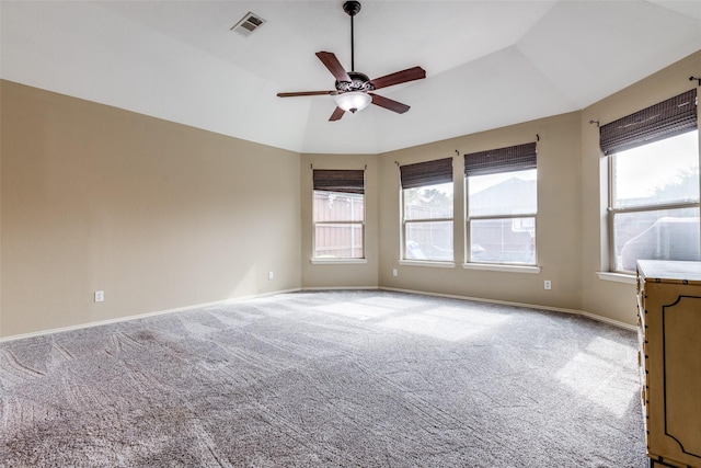 spare room featuring ceiling fan, carpet flooring, lofted ceiling, and a healthy amount of sunlight