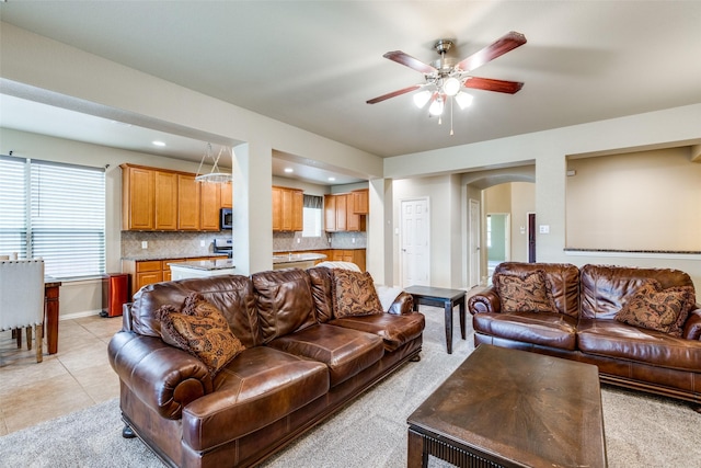 tiled living room with ceiling fan and a wealth of natural light