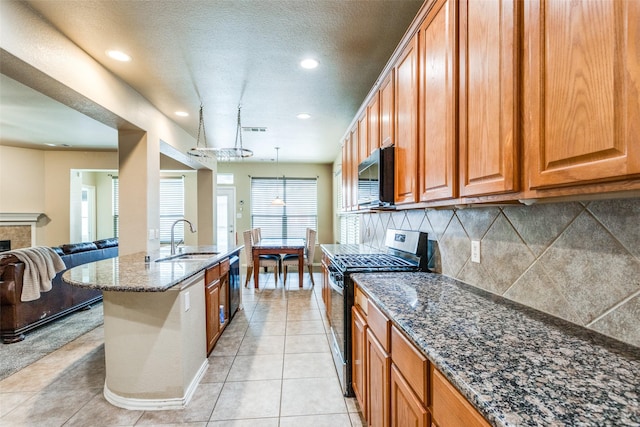 kitchen with decorative light fixtures, sink, appliances with stainless steel finishes, and dark stone countertops