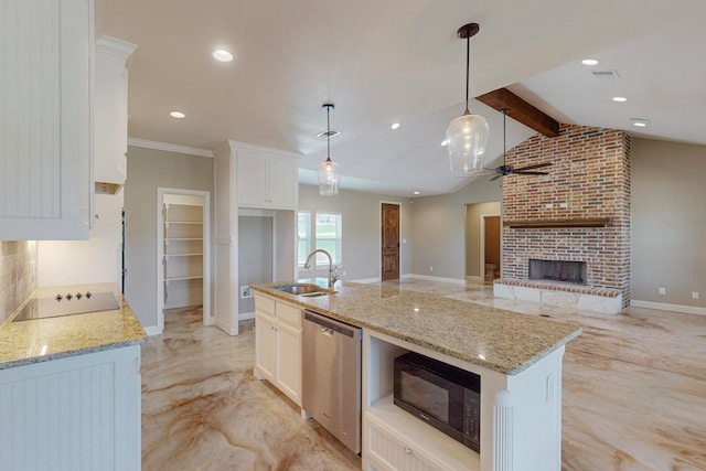 kitchen featuring an island with sink, a brick fireplace, black appliances, hanging light fixtures, and vaulted ceiling with beams