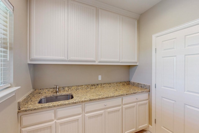 kitchen featuring light stone counters and sink