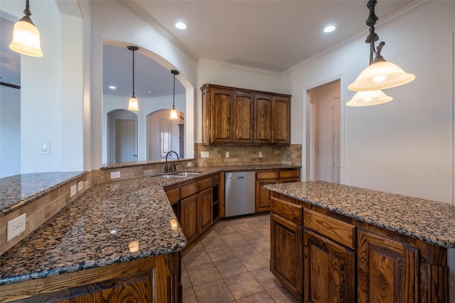 kitchen with stainless steel dishwasher, dark stone countertops, a sink, arched walkways, and backsplash