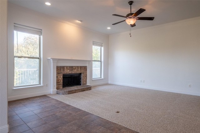 unfurnished living room with ceiling fan, baseboards, dark carpet, and ornamental molding