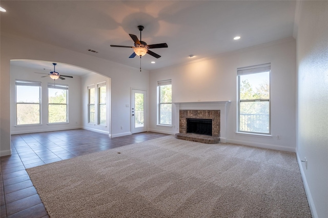 unfurnished living room featuring plenty of natural light, ornamental molding, and ceiling fan