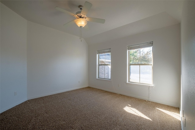 carpeted empty room with lofted ceiling, a ceiling fan, and baseboards