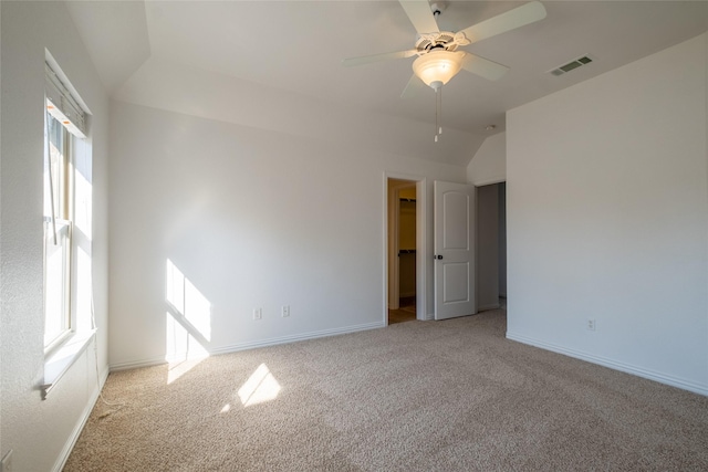empty room featuring visible vents, light colored carpet, and a healthy amount of sunlight