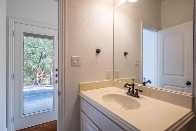 bathroom featuring a textured wall and vanity
