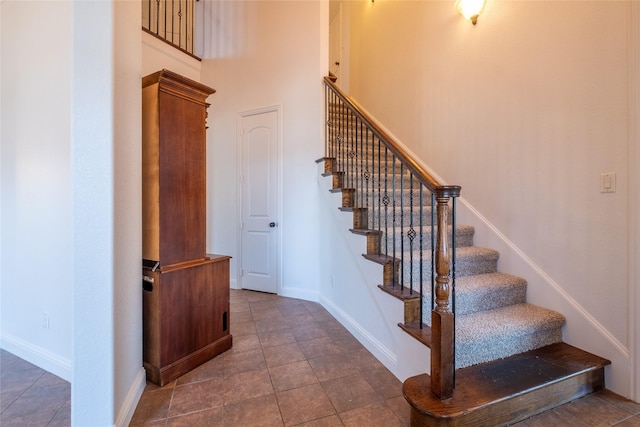 stairs with tile patterned floors and baseboards