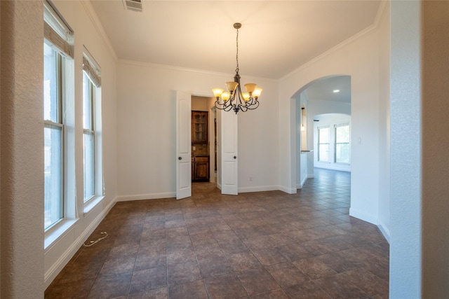 unfurnished dining area with an inviting chandelier, visible vents, arched walkways, crown molding, and baseboards