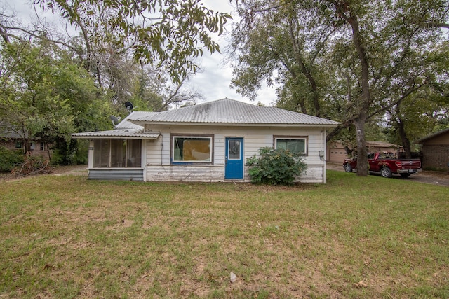 view of front facade with a sunroom and a front yard