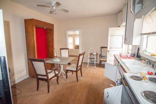 dining room with a healthy amount of sunlight, ceiling fan, sink, and light hardwood / wood-style floors