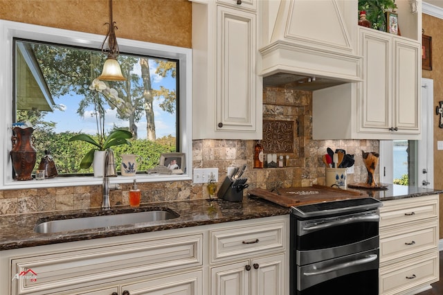 kitchen with premium range hood, sink, decorative light fixtures, stainless steel range with electric cooktop, and a healthy amount of sunlight