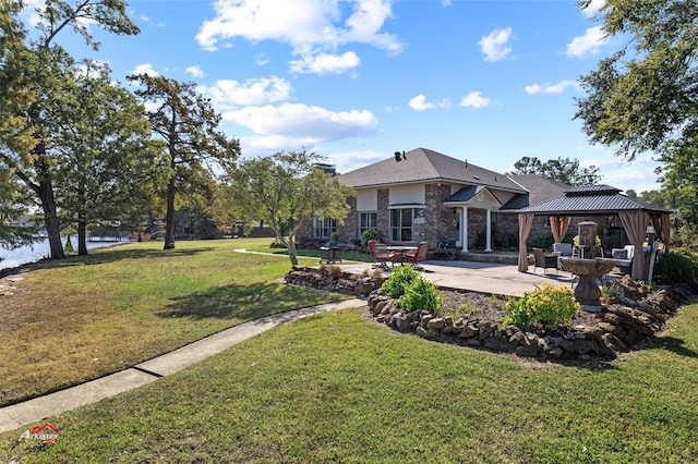 rear view of property featuring a gazebo, a yard, and a patio area