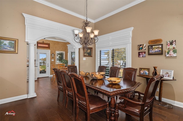 dining room with ornamental molding, a notable chandelier, decorative columns, and dark hardwood / wood-style flooring