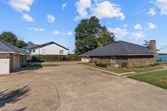 exterior space with a garage and a water view