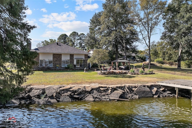 exterior space featuring a water view, a gazebo, and a lawn