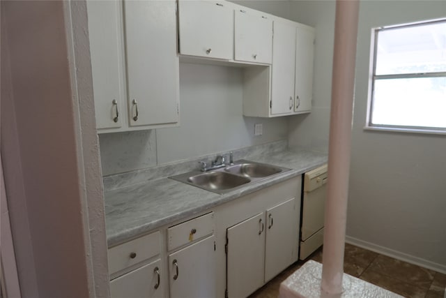 kitchen with white dishwasher, tile patterned flooring, sink, and white cabinets