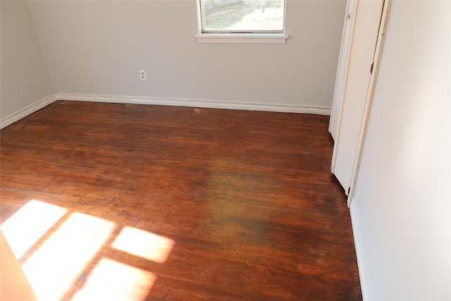 empty room with dark hardwood / wood-style flooring