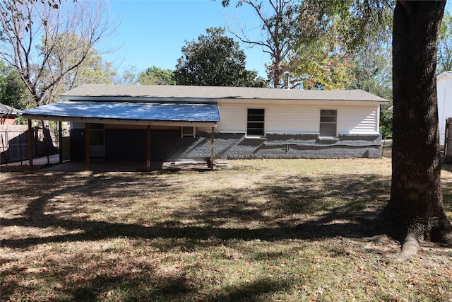 rear view of property featuring a lawn