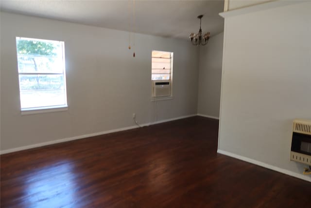 empty room featuring dark wood-type flooring, heating unit, an inviting chandelier, and cooling unit