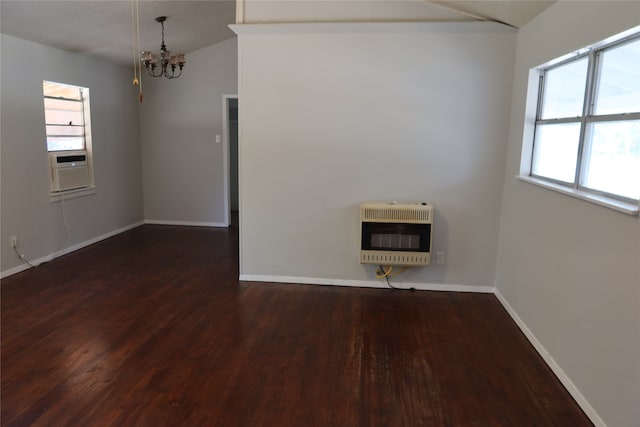 spare room featuring dark wood-type flooring, heating unit, a notable chandelier, vaulted ceiling, and cooling unit