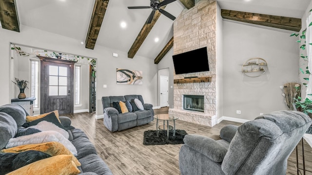 living room featuring lofted ceiling with beams, a fireplace, ceiling fan, and hardwood / wood-style floors