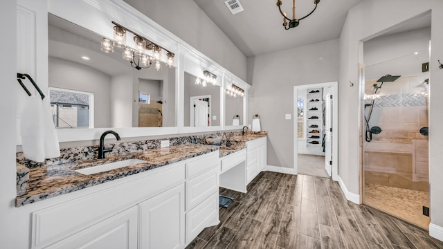 bathroom featuring hardwood / wood-style floors, vanity, and a shower with shower door