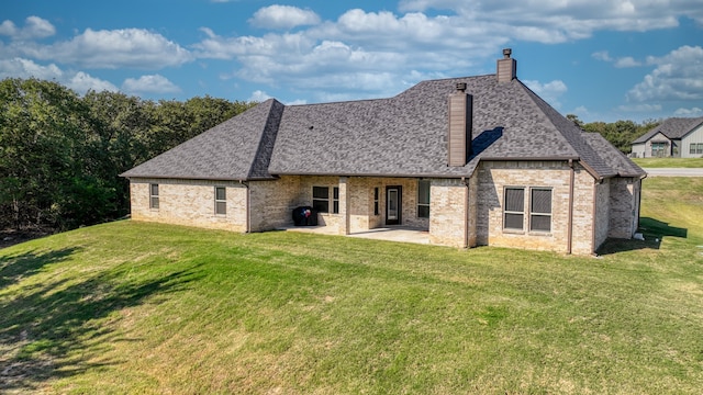 rear view of property with a lawn and a patio