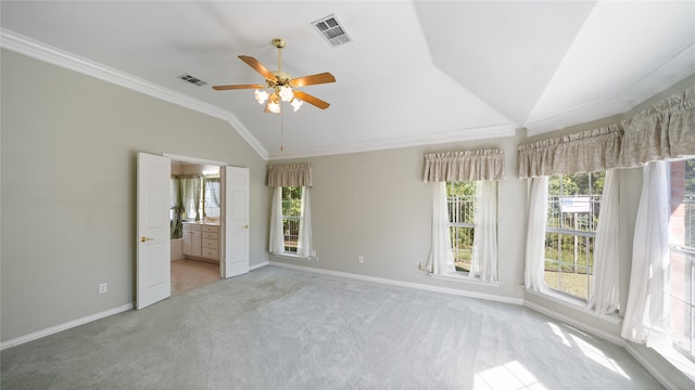 unfurnished bedroom with ceiling fan, connected bathroom, crown molding, vaulted ceiling, and light colored carpet