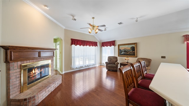 office space with lofted ceiling, a fireplace, crown molding, and hardwood / wood-style flooring