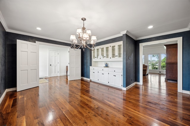 unfurnished dining area featuring crown molding, dark wood-type flooring, and a chandelier