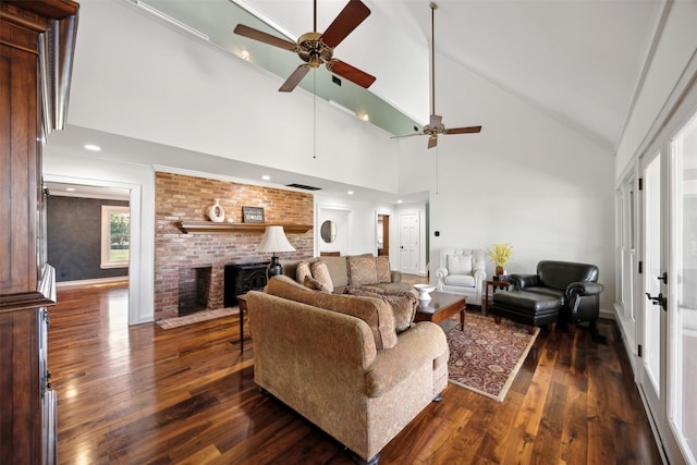 living room with dark wood-type flooring, a brick fireplace, high vaulted ceiling, and ceiling fan